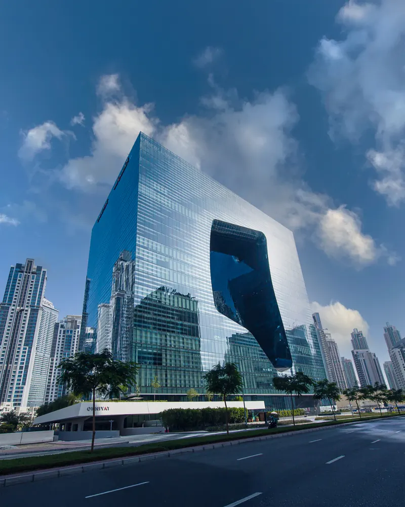 Close view of The Opus showing the mirrored glazing of the facade and the curved surface of the void.
